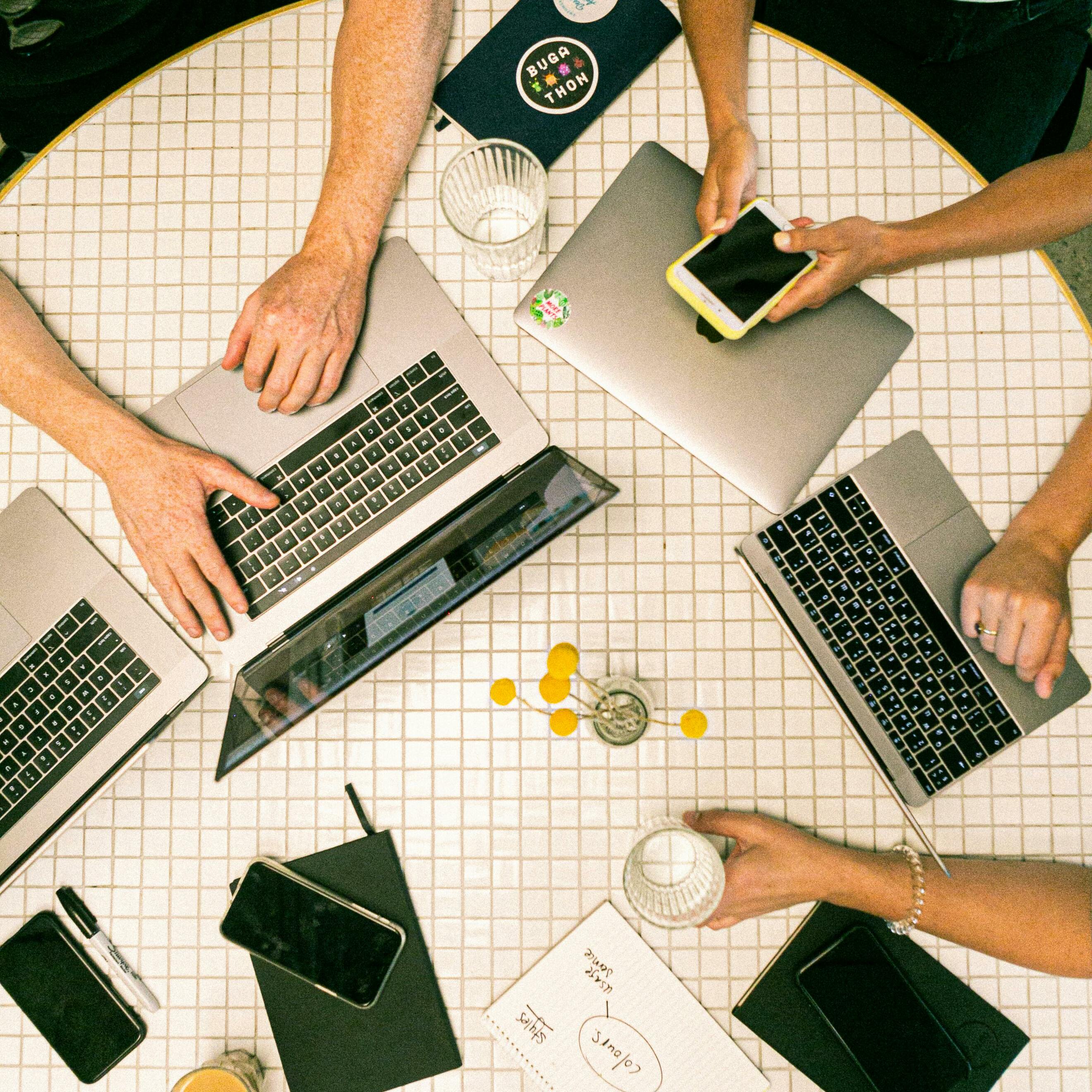 Laptops and hands on the table