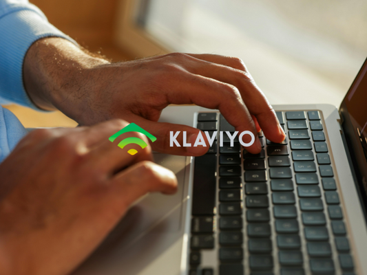 Man typing on laptop Klaviyo logo